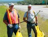 Mac McPherson and Anthony Schmidt hold up grabber tools along the Parks Highway, which they say they’ve adopted by cleaning for the past two years. The pair regularly clean the highway, even 