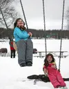 Stephanie Rogers, right, watches her friend, Brea Fiedler, swing into the air behind the Willow Community Center during the Willow Winter Carnival on Saturday, Jan. 30. The carnival continues