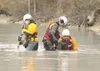 ROBERT DeBERRY/Frontiersman Above, dive and rescue team member
Pamela Freeman, left, uses a metal detector to search the
surrounding waters of the Knik River for metal debris as Ray Smith
wor