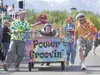 The Matanuska Electric Association bed-racing team brings their bed to a halt as a team member charges to ring the cow bell for the win at the finish line during the final championship race S