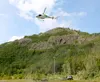 CJ Center, of the Alaska Division of Forestry, gives helicopter pilot Seamus O’Daimhin the OK to take off with a pallet of supplies in tow. The supplies were taken to the top of Bodenburg But