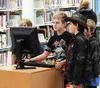(Matt Hickman/Frontiersman)Craig Elledge commands the keyboard as other kids hang around during Thursday’s ribbon cutting and open house at the new Wasilla Library.