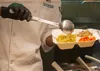 U.S. Air Force Airman 1st Class Robert Shorter, 673d Force Support Squadron food service apprentice, places food into a to-go box in the Iditarod Dining Facility on Joint Base Elmendorf-Richa