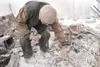 ROBERT DeBERRY/Frontiersman Frank Shor sifts through the ashes
of his cabin Monday afternoon. Shor lost everything in the early
morning blaze including several gold coins, his wallet and his
