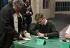 Alex Johnson, an eighth-grader at Colony Middle School, signs copies of the Knight Writers latest volume of 'With These Hearts and Hands' for his grandmother, Cathy Solem. The book includes d