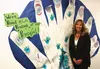 Academy Charter School founder and principal Barb Gerard smiles for a photo by a student and teacher art project created in her honor after being nominated for the National Life Group's 'Life