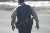 An Alaska State Trooper walks down Big Lake Road following a
shootout between Wasilla police and a 42-year-old Big Lake man
Tuesday afternoon. Police say John R. Rivera was killed after he
sh