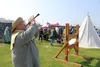 Greg Henrikson of The Historic Recrudescence Guild beckons attendees to spectate a sword fighting competition at the 2022 Alaska Scottish Highland Games. Jacob Mann/Frontiersman