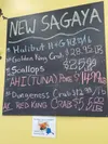 A blackboard at New Sagaya City Market in downtown Anchorage posts prices for crab and other fish on Dec. 1, 2023. A smaller sign celebrates last year’s resumption of the red king crab harves