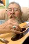 ROBERT DeBERRY/Frontiersman Herman Harold “Doc” South sings a
tune while he strums his guitar in his Valley home Monday
afternoon. South is a self-taught musician who has been playing
since h