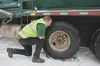 Alaska Waste employee Jim Dirks removes chains from his truck before getting onto the Palmer-Wasilla Highway Thursday morning. Dirks had a chain on his tire while working the side streets off