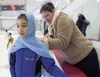 Courtney Villanueva gets help from her mom, Katie, with her head
scarf before the start of Saturday's Holiday Ice Fantasia Ice Show
at the Curtis D. Menard Memorial Sports Center in Wasilla. 