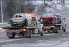 Tow trucks transport a red Toyota Corolla and a tan Toyota Corolla along the Parks Highway on Friday, Jan. 1, 2016. Alaska State Troopers said one person died and two were seriously injured w