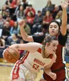 Wasilla's Layla Hays drives to the basket on Mountain City Christian Academy's Jasmine Schaeffer on Friday, March 8, 2024, at the Northern Lights Conference tournament at Soldotna High School