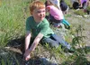 Kindergartener Aiden Shaw digs a hole for flowers at Machetanz Elementary School on Thursday, May 12. CAITLIN SKVORC/Frontiersman.com