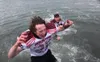 Houston junior Gordon Ratcliffe jumps into the Arctic Ocean with a tammate after the Hawks scored a win in Barrow for the first time in school history. Courtesy photo