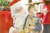 ROBERT DeBERRY/Frotiersman Blaze Hronkin, 3, receives his first
wooden toy dog made by Jay Wickham in his Palmer wood shop.
Wickham, dressed as Santa, will give out close to 400 wooden dogs
a