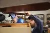Mat-Su Valley Rebuild owner Tim Zalinger cleans a ceiling fan at the store he opened inside the Trinity Lutheran Church building. Jacob Mann/Frontiersman