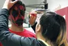 Job Corps Student Government Association President Tiani Beaman paints the face of student Silace Pounds in preparation for the school's Halloween dance on Wednesday evening. CAITLIN SKVORC/F