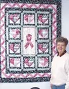 Sylvia Stewart of Sylvia's Quilt Depot shows off the breast
cancer awareness quilt. Customers donated the heart squares, Linda
Conover completed the top, and Stewart did the quilting. Photo b