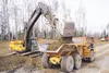 Byler Contracting excavator operator Dennis McKoon dumps dirt into the back of a truck driven by Kevin Rowe while working on the dirt work for the new Bluffs of Summer subdivision off Church 