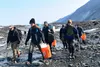 Military and civilian searchers hike across Colony Glacier June 13, 2022, to reach the remnants of a military plane crash. The team is working to recover the remains of 52 passengers and crew