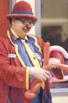 ROBERT DeBERRY/Frontiersman ‘Marky the Clown’ twists together
some balloons to make a magic wand for students at last week’s
Tanaina Elementary School book fair and family night.