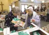 ROBERT DeBERRY/Frontiersman Volunteer Sandy Harkins, left, helps
Mary Francis Hoyle gather food at Saturday’s Valley Thanksgiving
Blessing at Good Shepherd Lutheran Church in Wasilla. Robert 