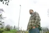 ROBERT DeBERRY/Frontiersman Wasilla resident Jeff Carney stands
on his property where he has a windmill that feeds power back into
the Matanuska Electric Association power grid. Carney is the