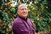 Dennis Holbrook, president and owner of South Tex Organics, stands among his grapefruit trees.