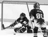 Josh Souder lunges for the loose puck as Tyler Apling comes in
to lend a helping hand in Saturday's MAHA Squirt game against the
Anchorage Red Wings. Photo courtesy of The Sports Section.