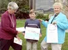 Audrey Leighton of the Society of Children's Book Writers and
Illustrators presents 7-year-old Tobin Sworts his award for the
best poster for the Book Bonanza, as his art teacher, Peggy
Compt