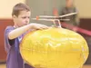 ROBERT DeBERRY/Frontiersman Teeland Middle School sixth-grader
L.J. Bohlmann concentrates on balancing his glider atop a balloon
he will raise to the ceiling and use as a launching pad during