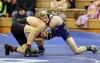 Wasilla's Alex Logsdon tries to keep a grip on the leg of Palmer's Peyton Portney during the 120-pound match of a dual Thursday night at Palmer Junior Middle School. Logsdon used an 11-2 majo