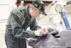 (ROBERT DeBERRY/Frontiersman) Mark Johnson works on taking apart
a snowmachine seat cover Friday at the company's location off the
Palmer-Wasilla Highway.