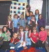 Mary Farina of the Talkeetna Volunteer Fire Department accepts a
baby quilt made by Brownie Troop 293 as part of one of their
community service projects. Submitted photo.