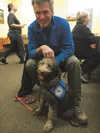 Linwood Fiedler, a board member at Arctic Paws for Service, sits with service-dog-in-training Smiley before the Tuesday meeting of Kiwanis Club at Turkey Red in Palmer. Kiwanis Club donated $