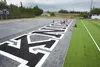 Workers with Beyond the Turf place the ‘H’ on ‘Knights’ in the end zone of the football field at Colony High School. The Palmer High School field at Machetanz Stadium also got artificial fiel