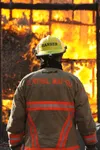 Firefighter Christopher Hansen watches as fire engulfs the house along Old Matanuska Drive Saturday afternoon. Several firefighters spent most of Saturday training in the house, which was pre