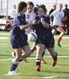 Wasilla freshman Ally Hull splits a pair of North Pole defenders during a 5-0 win over the Patriots April 10 at Wasilla High School. Jeremiah Bartz