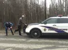 An Alaska State Trooper examines the shoes of Richard "Ole" Larson on Wednesday after Larson shot a man fleeing a police chase in Larson's Wasilla neighborhood. Larson has not been charged wi