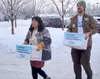 Rep. Genevieve Mina, D-Anchorage, and Carey Fristoe, owner of Black Spruce Brewery in Fairbanks, carry signed petition booklets for Ballot Measure 1 on Jan. 9, 2024, in Anchorage. They were a