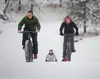 Stefan Hinman and Patty Sullivan race up a small incline on a pair of fat-tire bikes during Winter Trails Day Saturday at Government Peak Recreation Area. ROBERT DeBERRY/Frontiersman.com