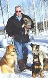 Ted Berry holds a Eurasier puppy, one of the first of the breed
to be born in Alaska. At left is Fritz, the puppy's father. Berta,
its mother, is on the right looking up at Berry. In the fore