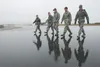Active duty Airmen assigned to the 3rd Wing, Reserve Airmen from the 477th Fighter Group and Alaska Air National Guardsmen from 176th Wing conduct a foreign object debris walk at Joint Base E