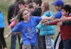 Third-grader Cash Fucina runs through a line of high-fives at the end of the kids' marathon at Finger Lake Elementary School on Wednesday, May 18. Students ran 1 mile on Wednesday to complete