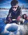 "I got a nibble,” says George, fishing with the pole he made himself earlier in the week. The lesson runs deeper than the hole in the ice. Russell Clark/For the Frontiersman