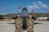 U.S. Air Force Airman 1st Class Ethan Koetter, 673rd Communication Squadron Cyber Control operator, left, and Technical Sgt. Matthew Vile, 673rd CS NCOIC of Cyber Control Operations pose for 