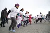 Jousette McKeel runs alongside Brooklynn Pruett during the Paint it Purple event April 18 in Wasilla. Heather A. Resz/Frontiersman