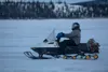 Gunnery Sgt. Jake Paolucci rides a snow machine across the Noatak River while traveling from Noatak, Alaska, to Kotzebue, Alaska, Dec. 14, 2021. Marines on snowmobiles delivered toys to boys 